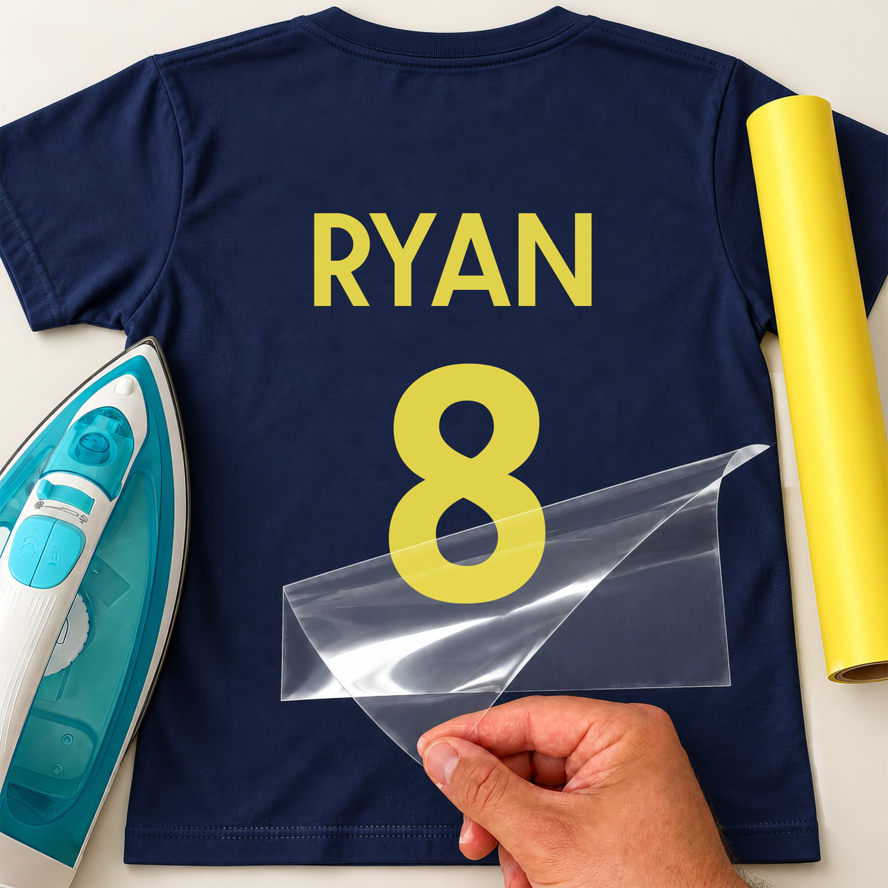 Hockey Shirt Name Number iron-on transfer: yellow RYAN 8 on a navy T-shirt, film being peeled