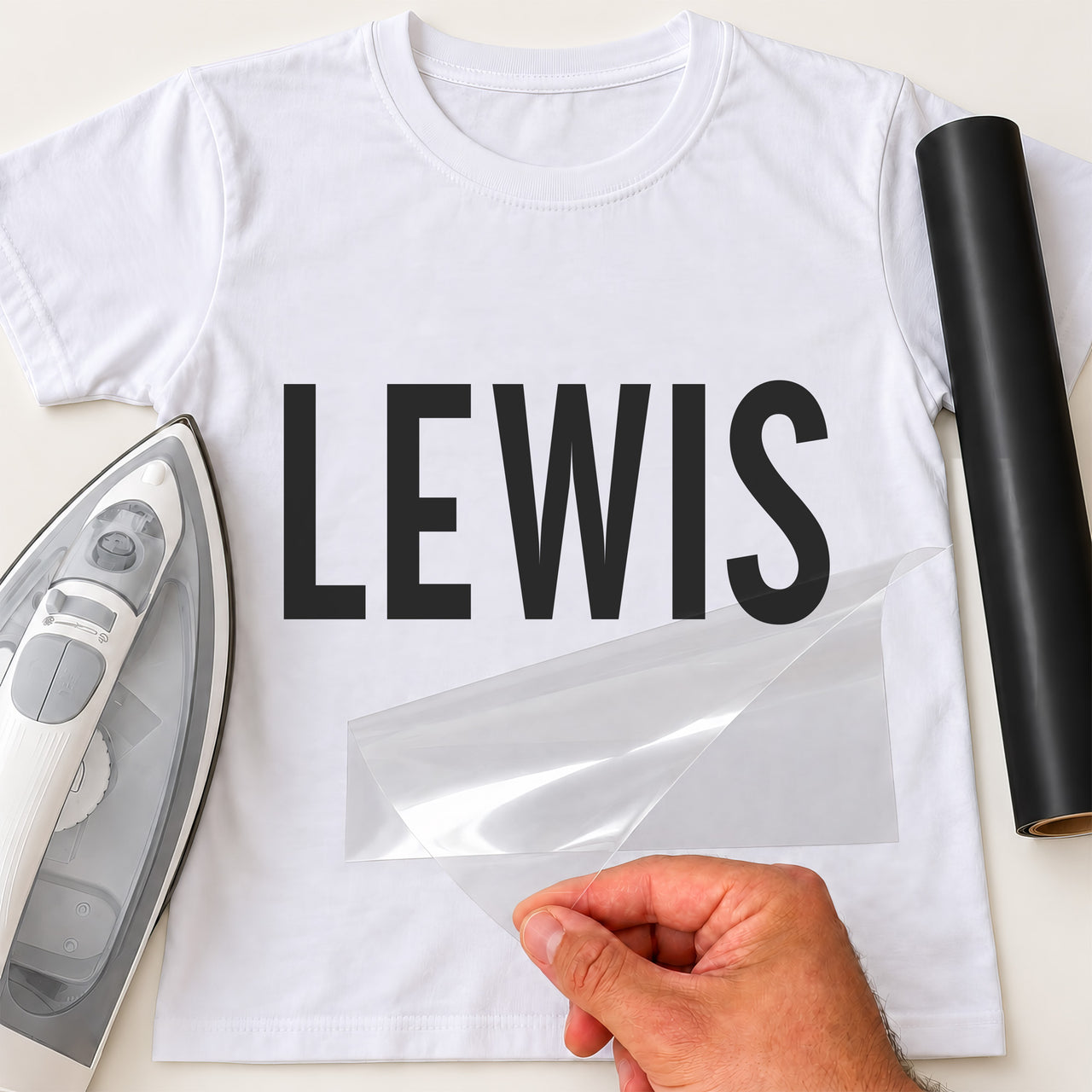 Personal Trainer Name iron-on transfer: black LEWIS on a white T-shirt, film being peeled