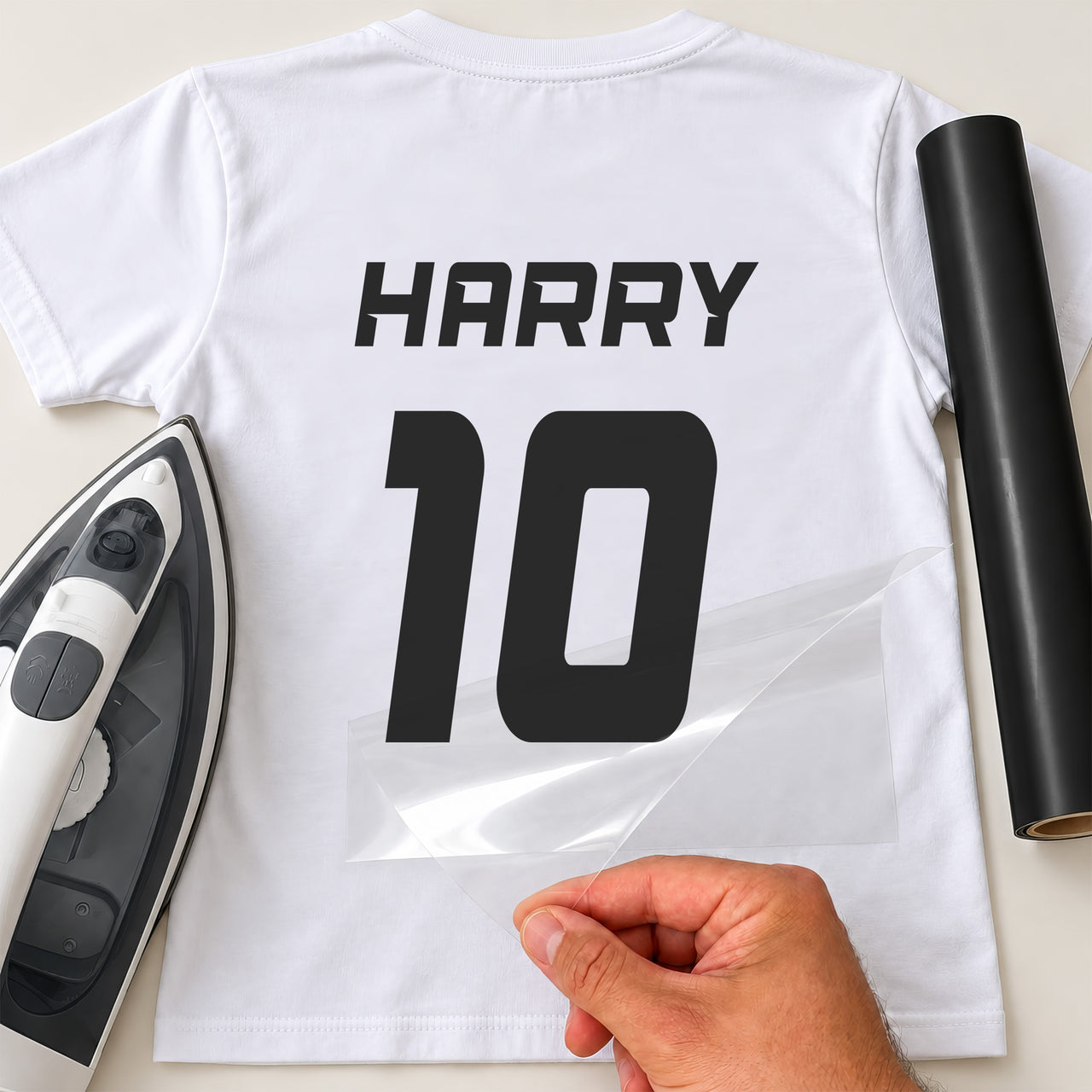 Sports Shirt Name Number iron-on transfer: black HARRY 10 on a white T-shirt, film being peeled