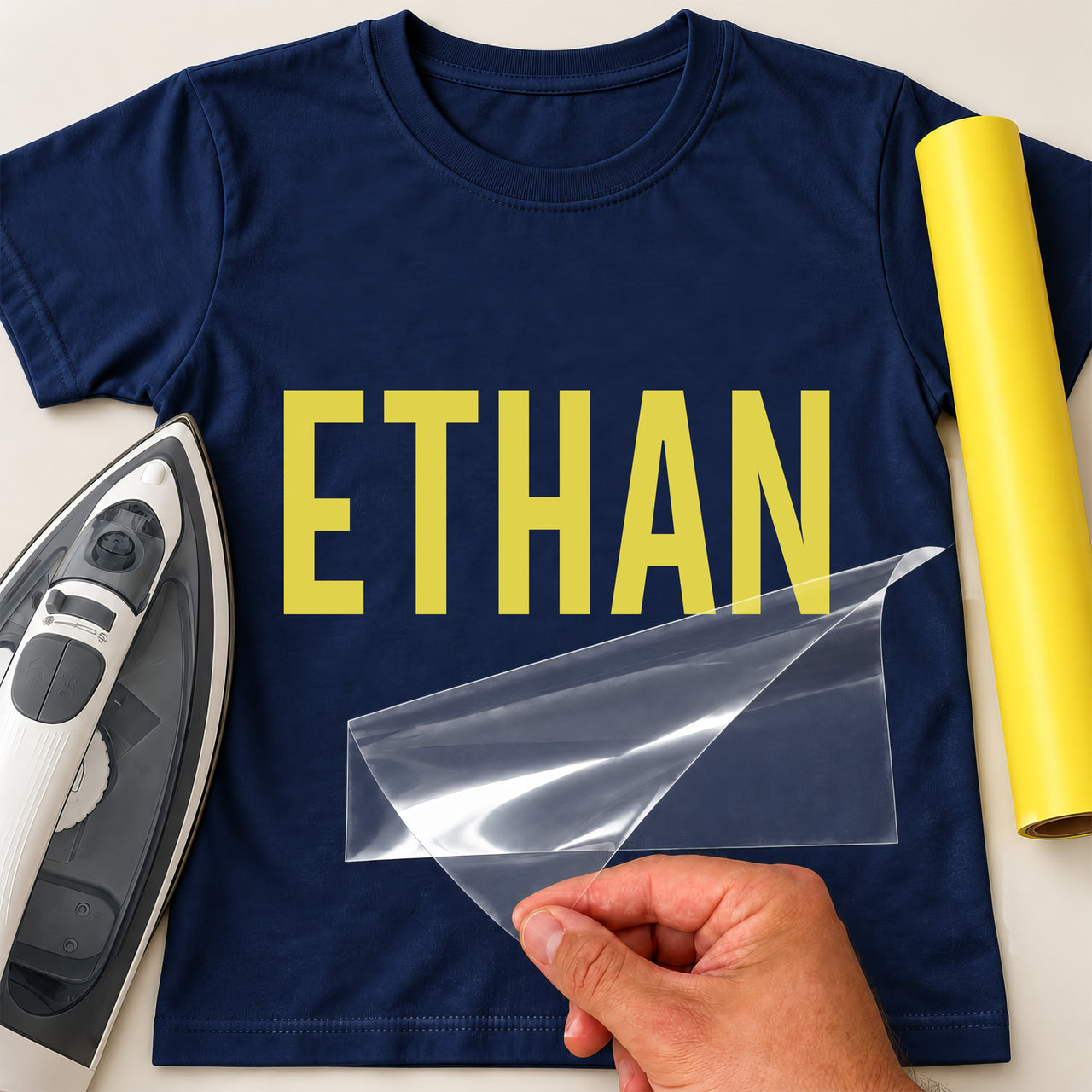 Swim Squad Name iron-on transfer: yellow ETHAN on a navy T-shirt, film being peeled