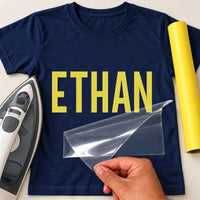 Swim Squad Name iron-on transfer: yellow ETHAN on a navy T-shirt, film being peeled