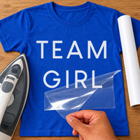 Team Boy / Team Girl iron-on transfer: white TEAM GIRL on a royal blue T-shirt, film being peeled