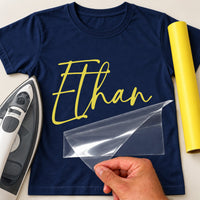 Team Bundle 5+ Names iron-on transfer: yellow script Ethan on a navy T-shirt, film being peeled