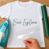 World Book Day iron-on transfer: green script Book Explorer on a white T-shirt, film being peeled