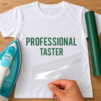 Professional Taster Apron iron-on transfer: green PROFESSIONAL TASTER on a white T-shirt, film being peeled