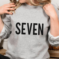 Seven Iron-On Transfer - 7th Birthday Age Word HTV Design shown on a sweatshirt