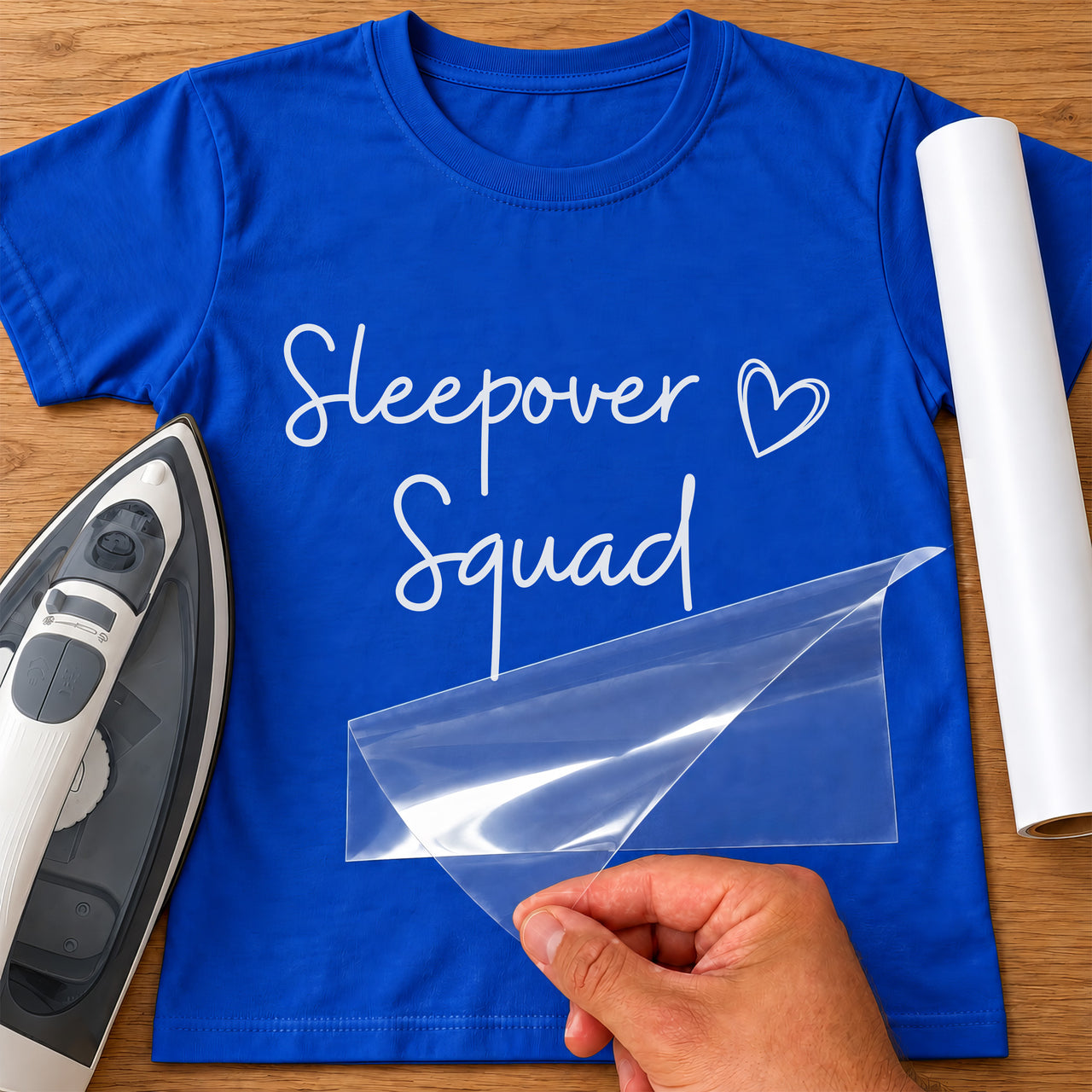 Royal blue T-shirt with white 'Sleepover Squad' iron-on transfer in handwritten script with heart, iron and white vinyl roll