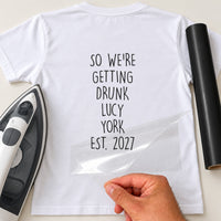 White T-shirt with 'SO WE'RE GETTING DRUNK LUCY YORK EST. 2027' in black, hen party iron-on vinyl transfer