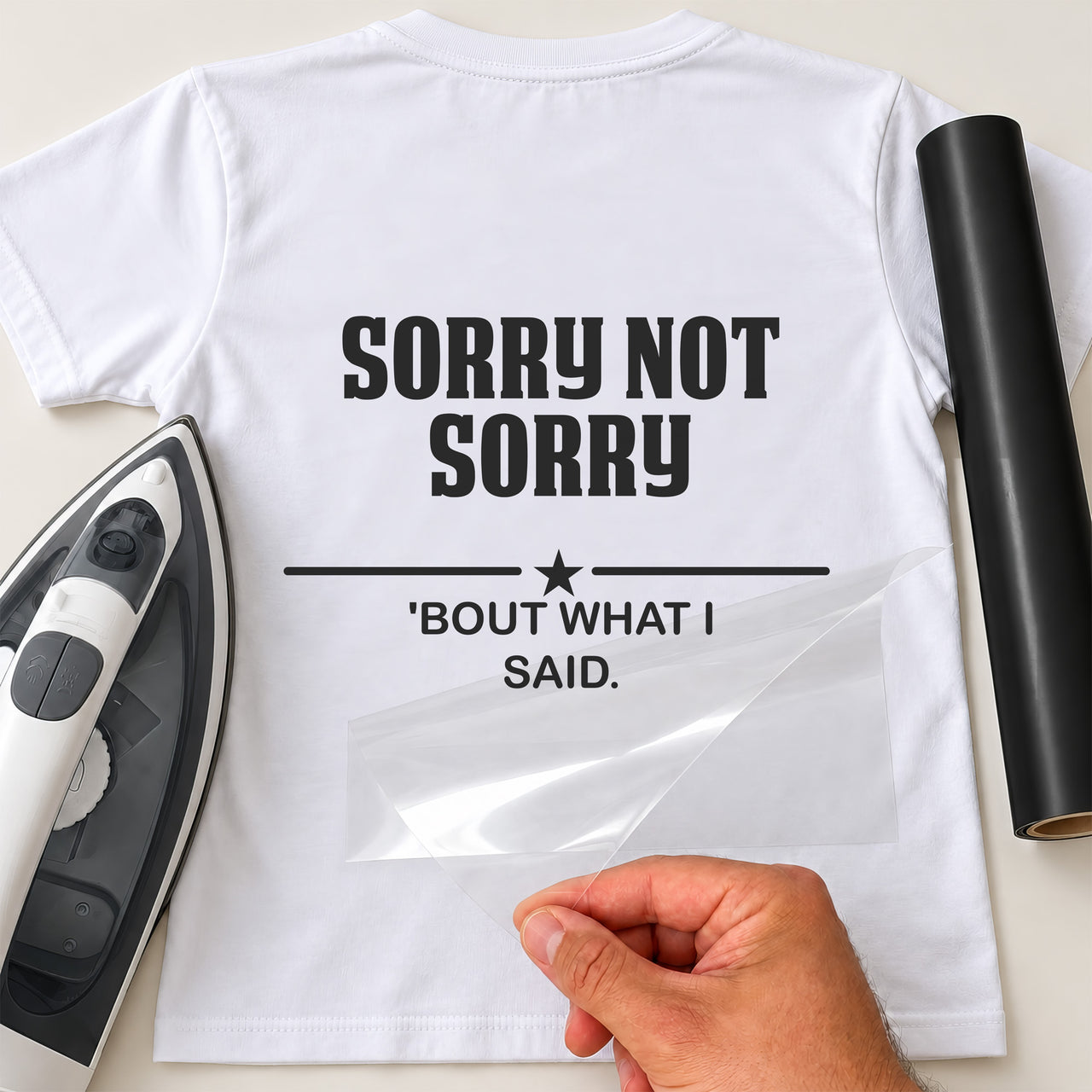Sorry Not Sorry iron-on transfer: black SORRY NOT SORRY 'BOUT WHAT I SAID on a white T-shirt, film being peeled