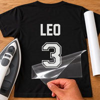 Sports Day Name Number iron-on transfer: white LEO 3 with outline number on a black T-shirt, film being peeled