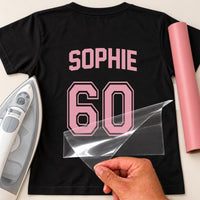 Black T-shirt back with pink 'SOPHIE' and outlined '60' jersey-style iron-on transfer, film peeled off, pink vinyl roll