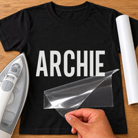 Stag Do Name iron-on transfer: white ARCHIE on a black T-shirt, film being peeled
