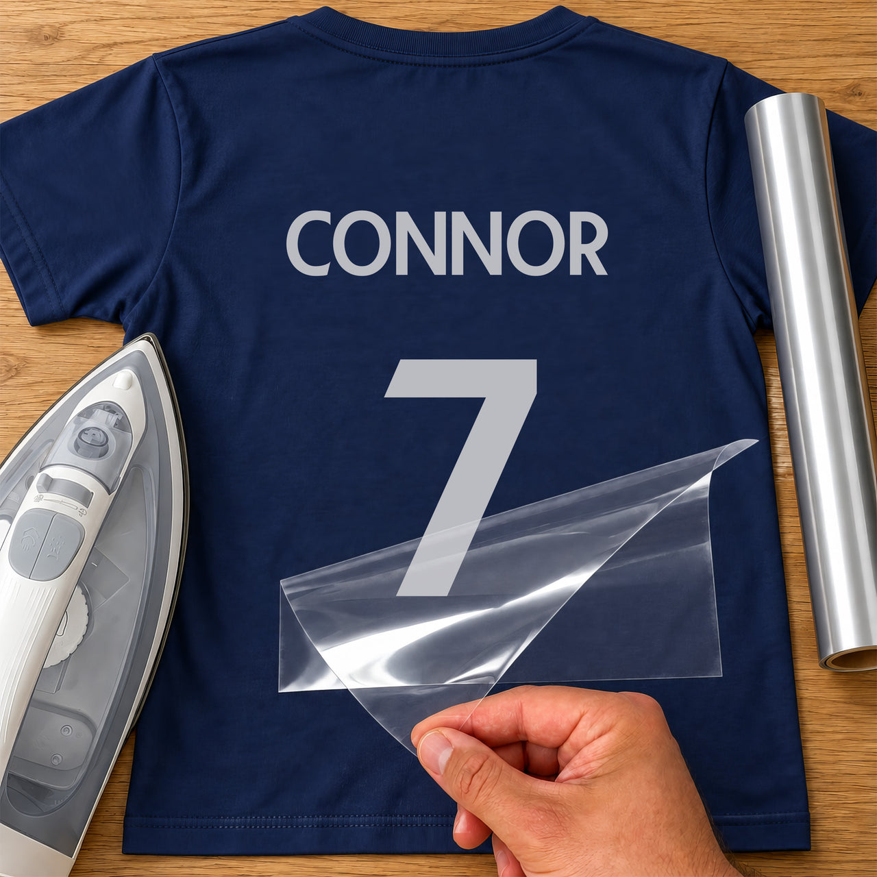 Sunday League Shirt Name Number iron-on transfer: silver CONNOR 7 on a navy T-shirt, film being peeled