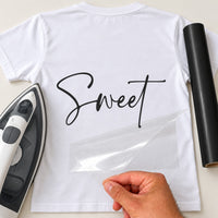 Back of a white T-shirt with black 'Sweet' signature script, carrier film being peeled off - iron-on vinyl transfer