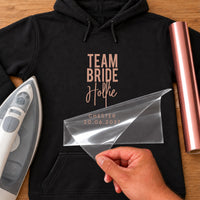 Black hoodie with rose gold 'TEAM BRIDE', 'Hollie' script and 'CHESTER 20.06.2027' iron-on transfer, iron and vinyl roll