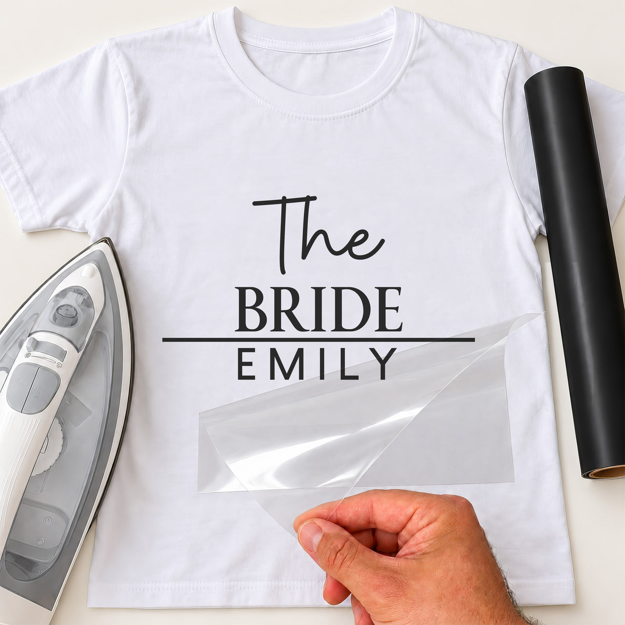 White T-shirt with black 'The BRIDE EMILY' transfer, script and serif lettering split by a line, film peeled away