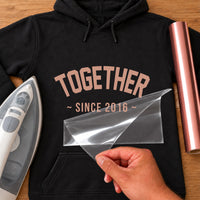 Together Since iron-on transfer: rose gold TOGETHER SINCE 2016 on a black hoodie, film being peeled