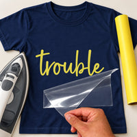 Navy T-shirt with yellow script 'trouble' iron-on transfer, iron and yellow vinyl roll
