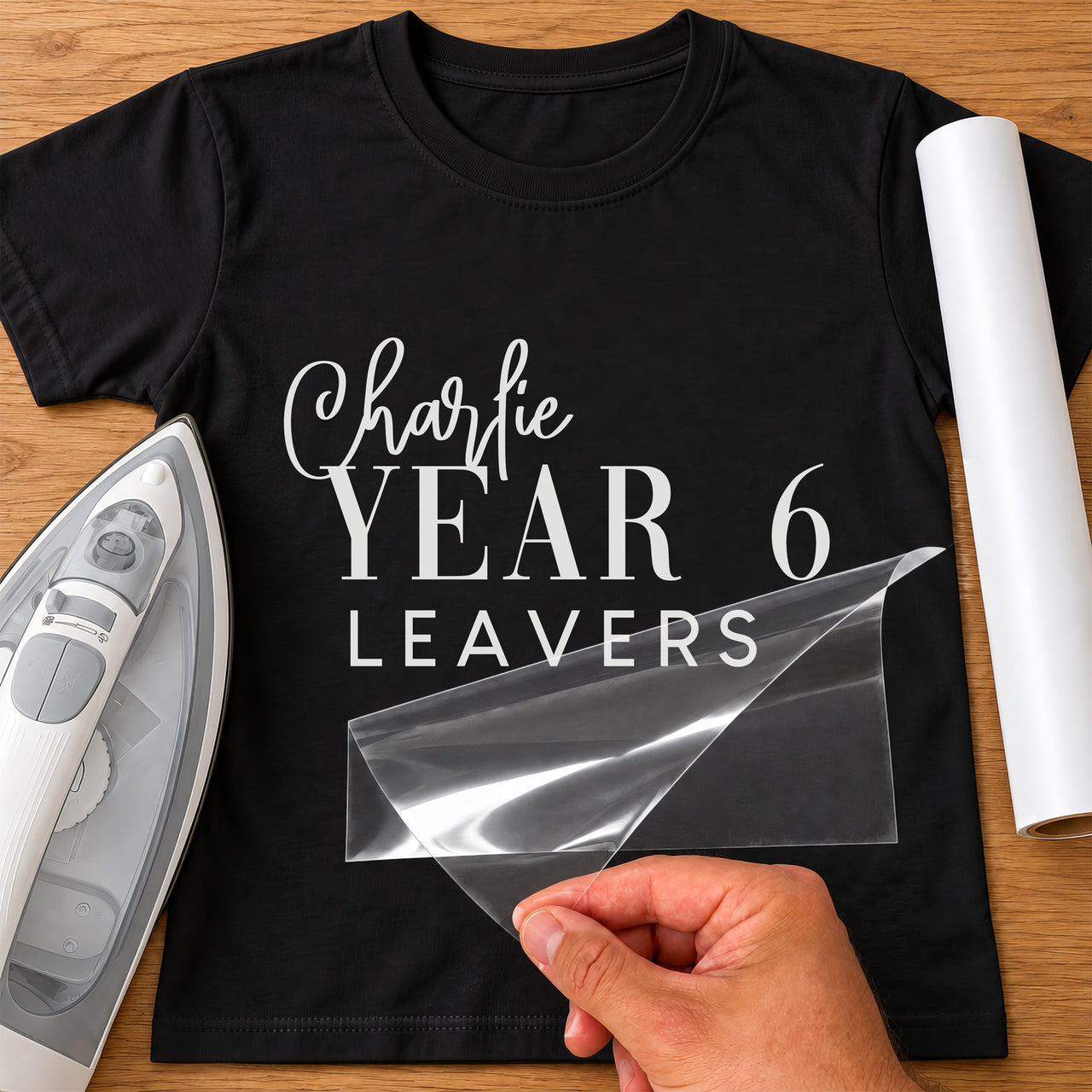 Year 6 Leavers iron-on transfer: white Charlie YEAR 6 LEAVERS on a black T-shirt, film being peeled