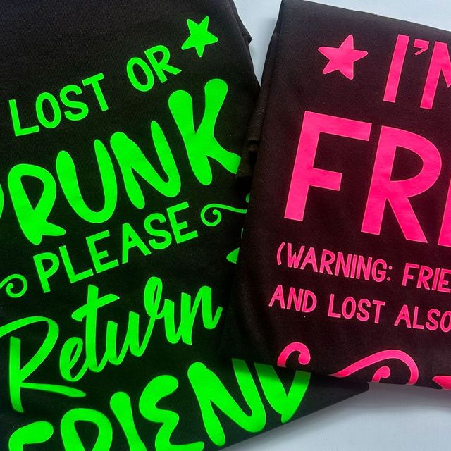 Black T-shirts with neon green and neon pink slogans